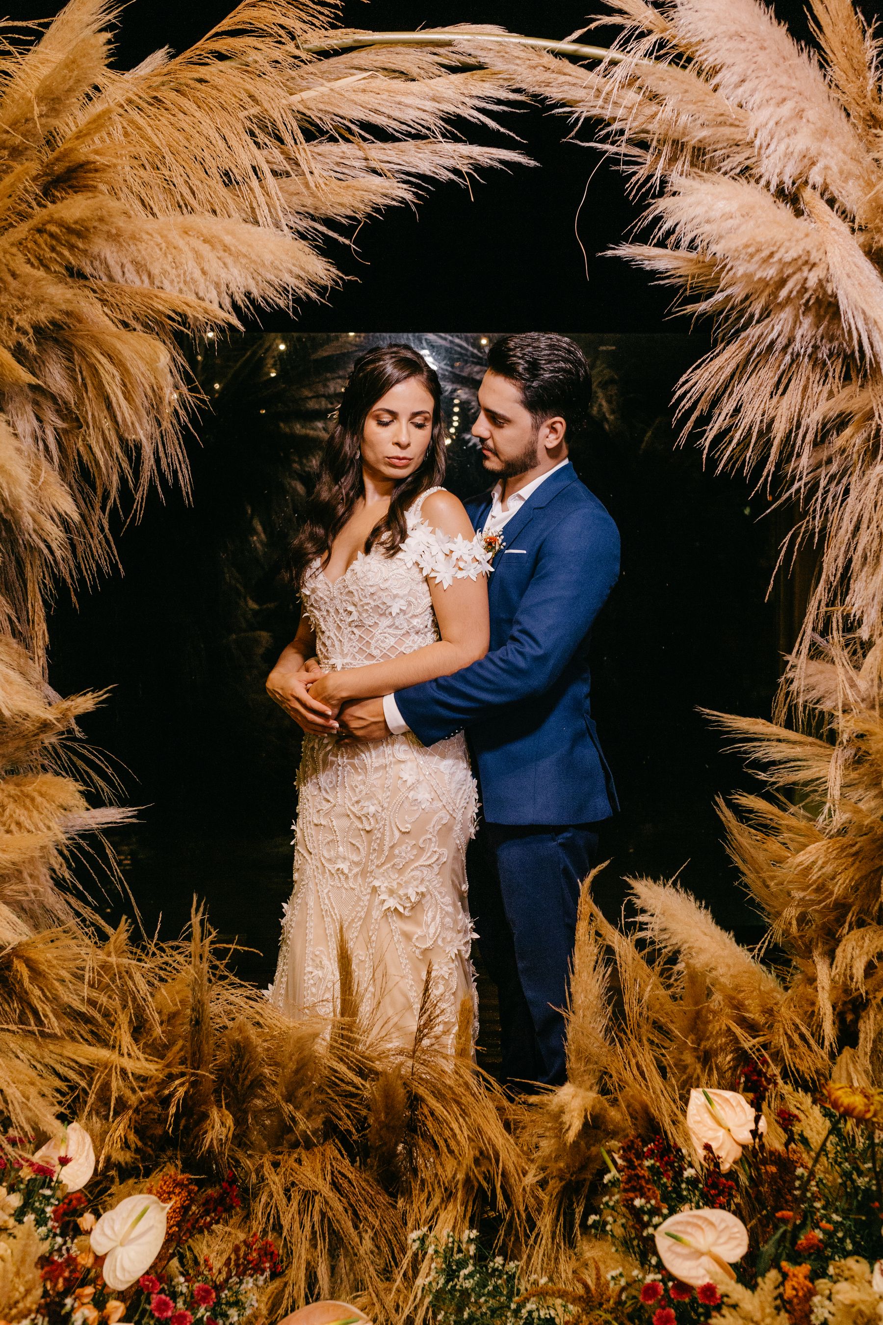 A newly married couple celebrating beneath flowers and warm lights